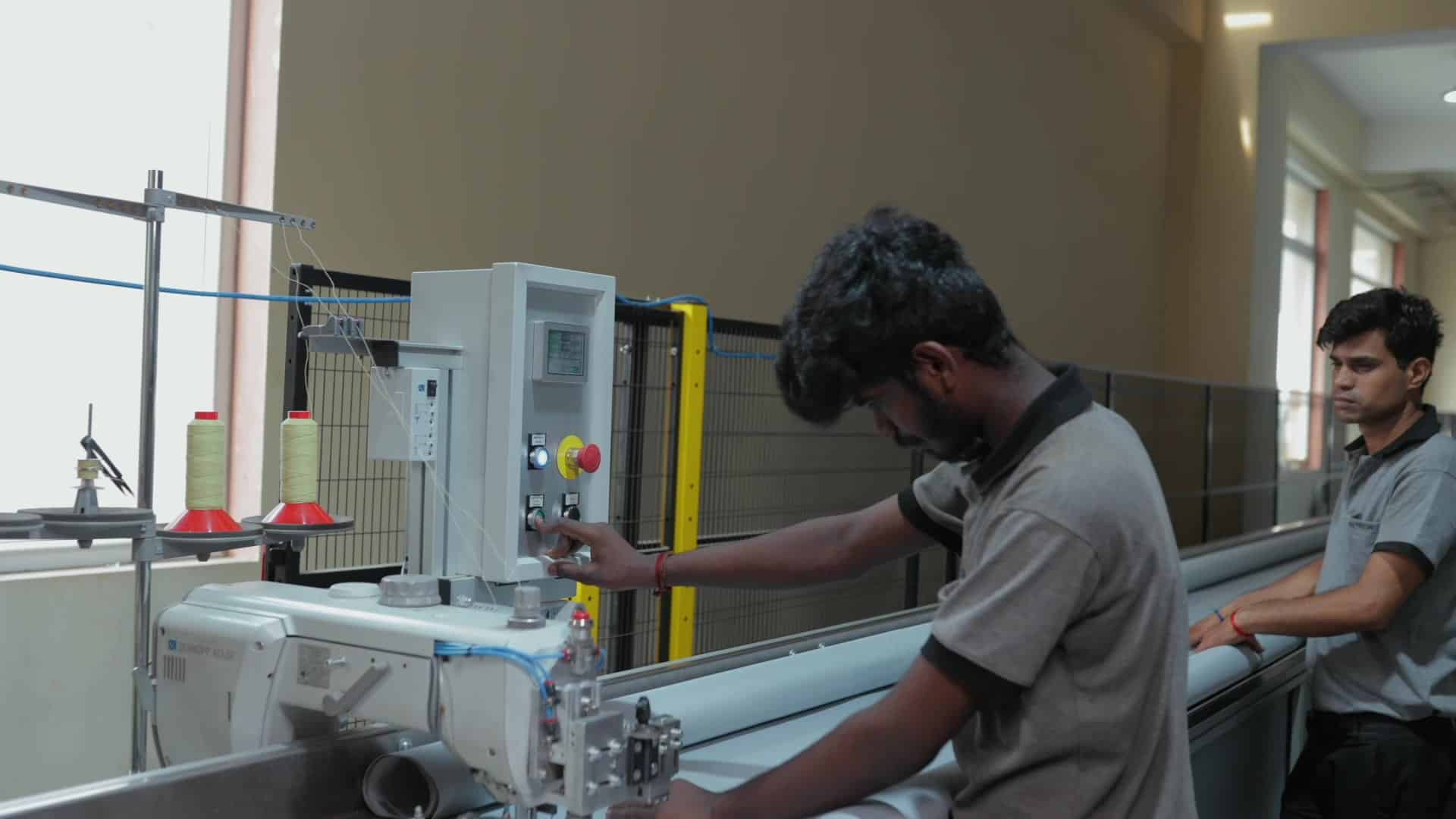 Technicians stitching fire curtain fabric on an industrial sewing line